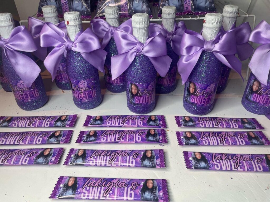Purple glittery bottles with bows and matching candy bars for a Sweet 16.