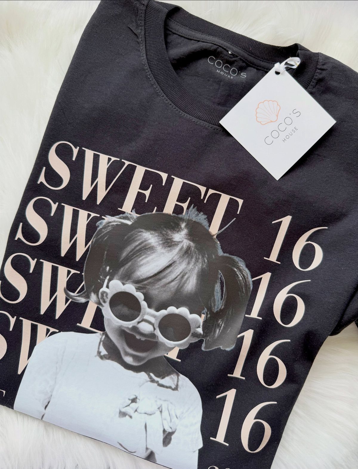 Black t-shirt with Sweet 16 text and a girl's graphic on white fur