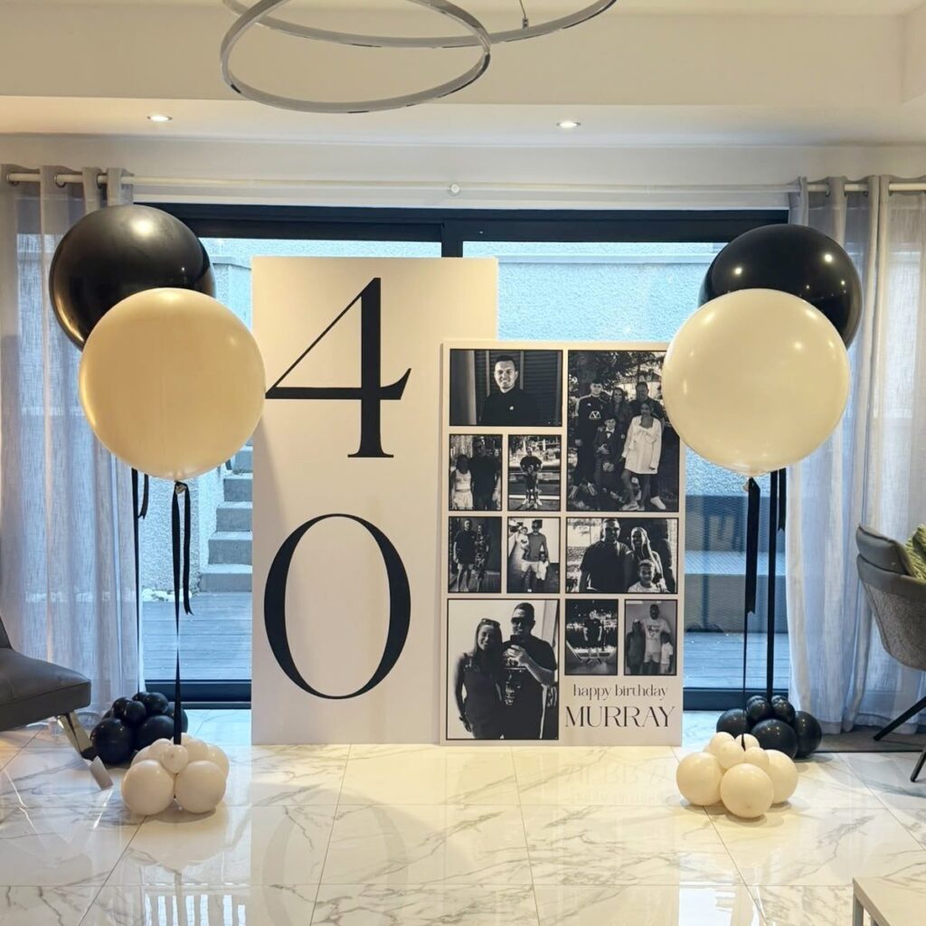Birthday decoration with large number 40, photo collage, and gold and black balloons.