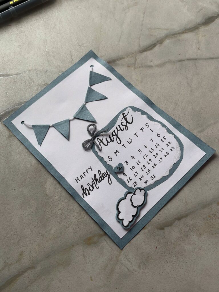Handmade birthday card with a blue bunting banner and an August calendar page.