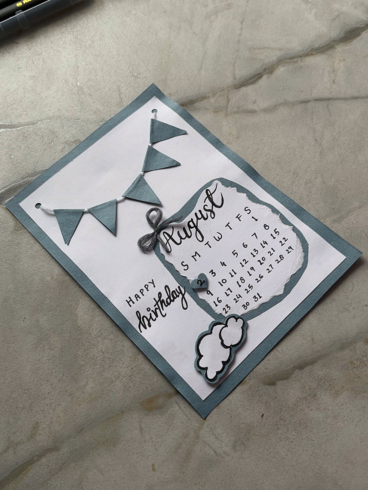 Handmade birthday card with a blue bunting banner and an August calendar page.