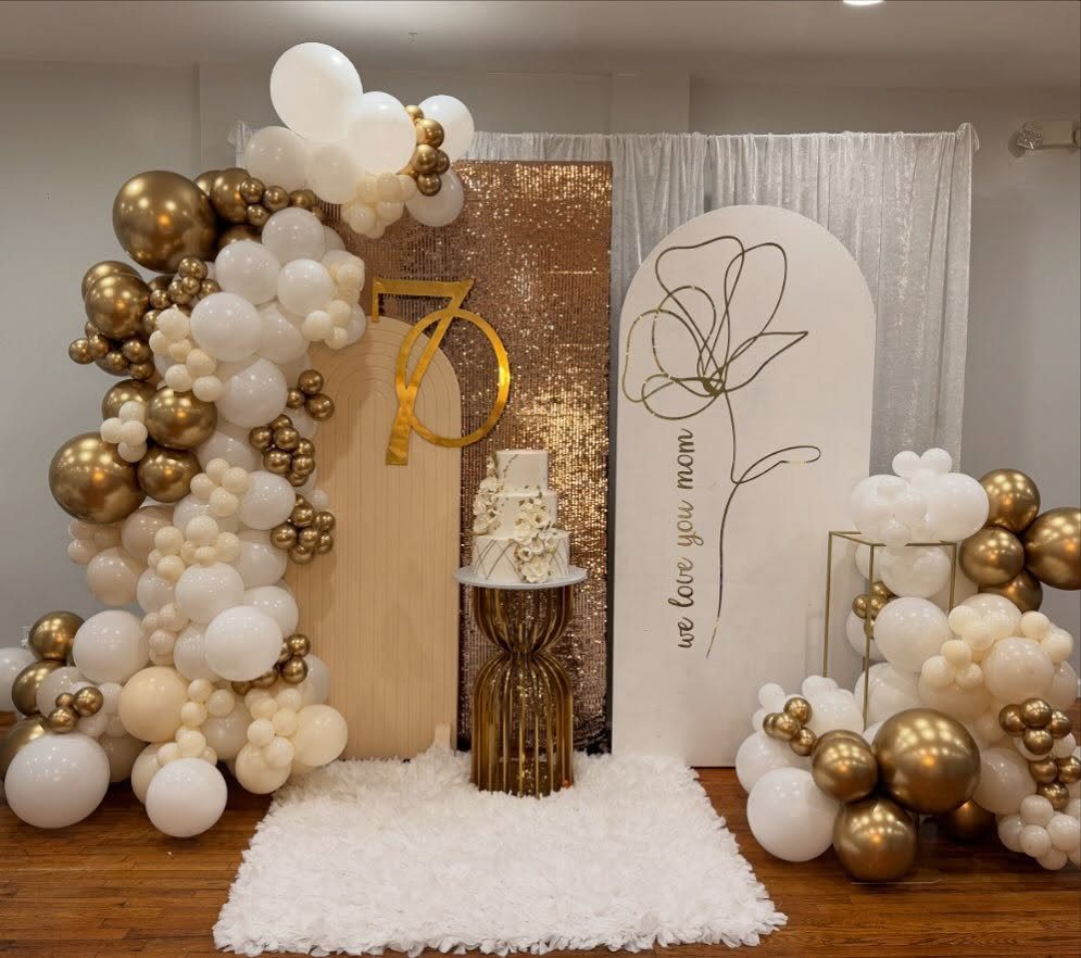 Birthday party decoration with gold and white balloons, a cake, and 70 sign.