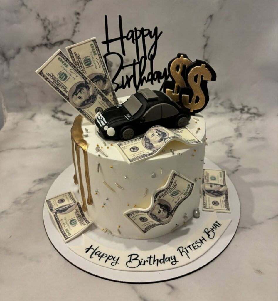 White birthday cake decorated with edible money, a black car, and gold accents.