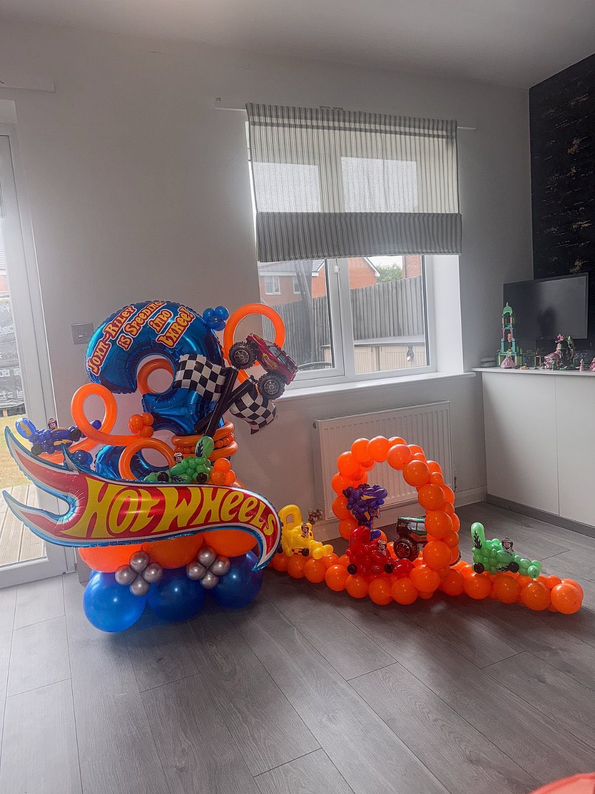 Hot Wheels themed balloon decorations with a logo and a balloon race track.