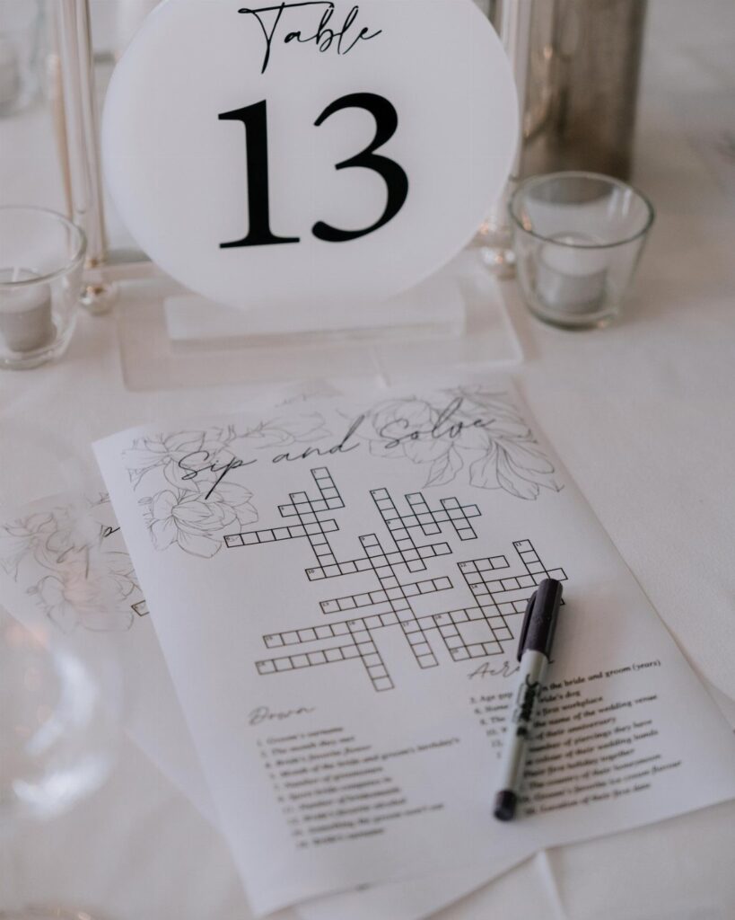 Crossword puzzle game on a white table next to a table number sign.